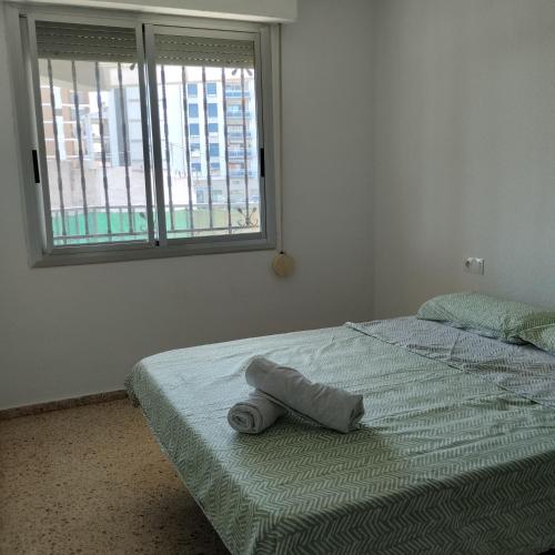 a bedroom with a bed with a towel on it at Burrianna Beach Apartment in Burriana