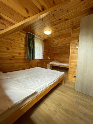 a bedroom with a bed in a wooden cabin at Ośrodek Szeligi in Ełk