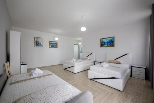 a white room with two beds and a mirror at Hotel Artur2 in Ksamil