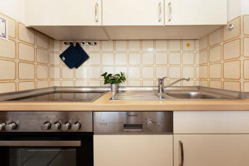 a kitchen with a sink and a stove at Schützenweg 6 Ostseesonne in Kellenhusen