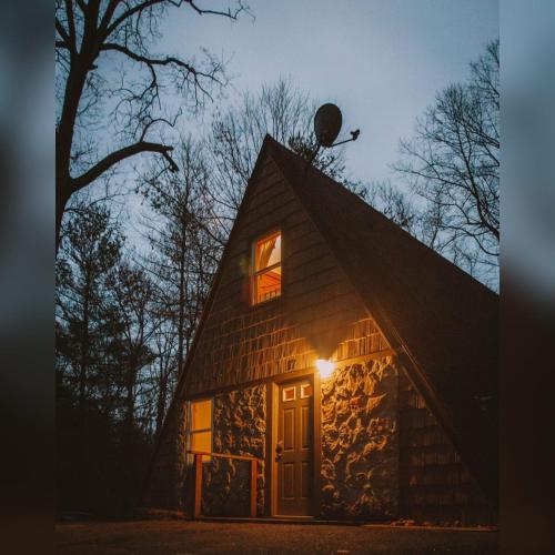 a barn with a light on the roof at night at A-Frame #03 - by The Chalets in Logan