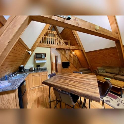 a kitchen and dining room with a wooden table at A-Frame #04 - by The Chalets in Logan