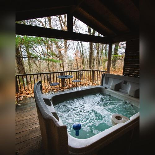 a hot tub on a deck with a table at A-Frame #05 - by The Chalets in Logan