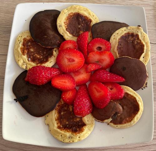 Un plato de panqueques con fresas y chocolate en La Maisonnette T2 charmant jardin parking La Cadière d'Azur 1 à 4 personnes, en La Cadière-dʼAzur