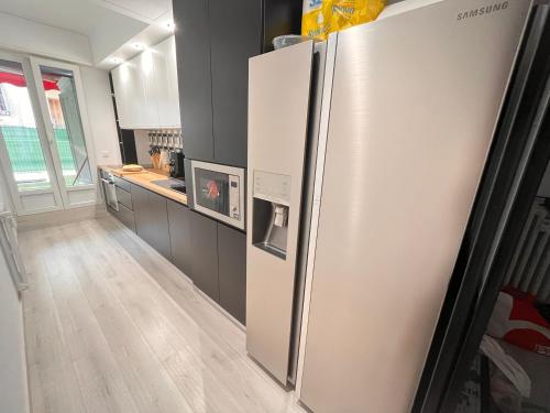 une cuisine avec un réfrigérateur en acier inoxydable dans une pièce dans l'établissement Nice Premium Rooms - Coliving Libération avec Terrasse & Salle de Bain Privée, à Nice