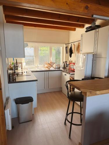 une cuisine avec des armoires blanches et une table et des chaises dans l'établissement Sur le pont d un bateau à Boulogne sur Mer, à La Celle-sous-Gouzon