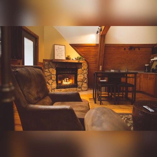 a living room with a couch and a fireplace at A-Frame #08 - by The Chalets in Logan