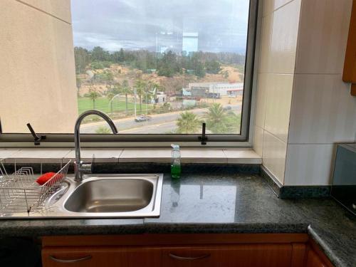 a sink in a kitchen with a window at San Alfonso del Mar Faro 702 in Algarrobo