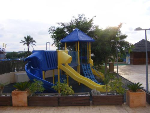 un parque infantil con un tobogán azul y amarillo en Apartamentos Europa House Sun Beach, en Guardamar del Segura