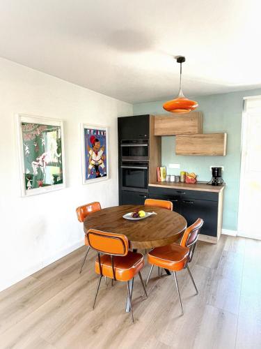 - une cuisine avec une table en bois et des chaises orange dans l'établissement Charming 3 bedroom with stunning views 5 minutes from the beaches, à Anglet
