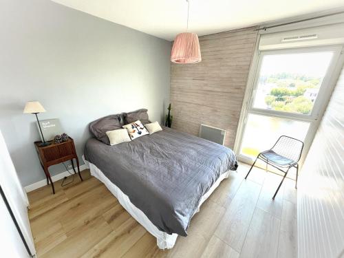 une chambre avec un lit, une chaise et une fenêtre dans l'établissement Charming 3 bedroom with stunning views 5 minutes from the beaches, à Anglet