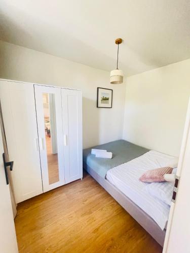 a small bedroom with a bed and a mirror at Sopot Modern Apartments 3 in Sopot