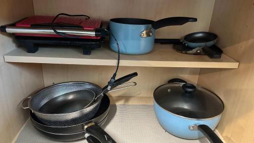 a shelf with some pots and pans and a pot and a pan at Big Studio with Ocean View max 6 sleepers in San Diego