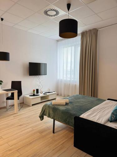 a bedroom with a bed and a desk with a chair at Zlatarooms 222 in Warsaw