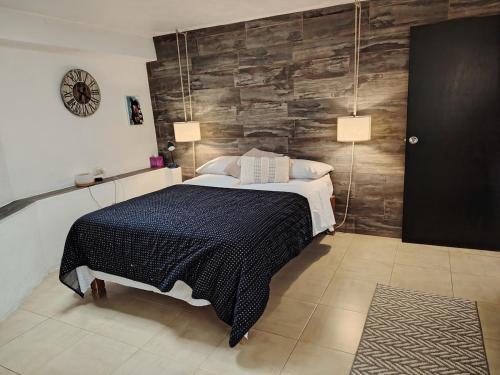 a bedroom with a bed and a wooden wall at Tiny House in Guanajuato