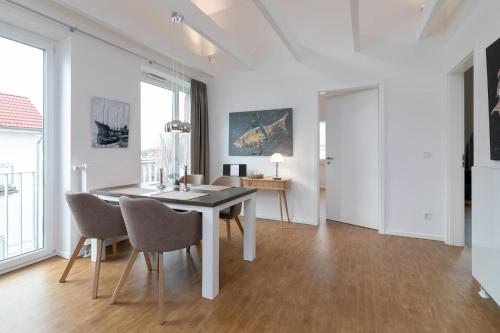 a dining room with white walls and a table and chairs at KellenHus Penthouse 2 in Kellenhusen