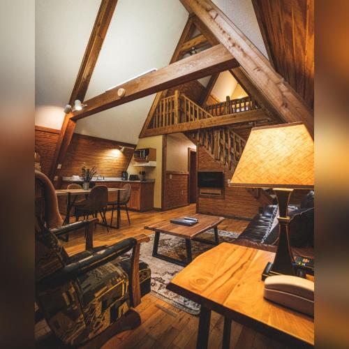 a living room with a table and a wooden ceiling at A-Frame #16 - by The Chalets in Logan