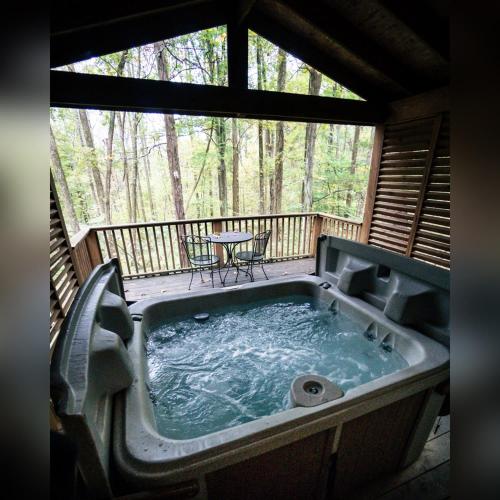 a jacuzzi tub on the deck of a cabin at A-Frame #16 - by The Chalets in Logan