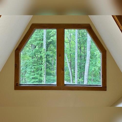 a window in a room with a forest at A-Frame #15 - by The Chalets in Logan