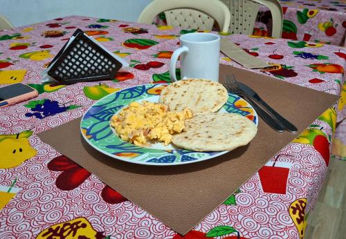 a plate of eggs and bread on a table at Posada Yulimar, Nuquí in Arusí