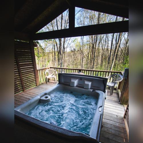 a hot tub on a deck with two chairs at A-Frame #14 - by The Chalets in Logan
