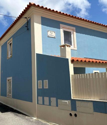 a blue and white building with a clock on it at Casa do Padeiro - Sintra Country Cottages II in Montelavar