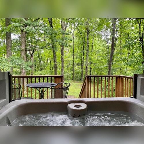 a hot tub on a deck with a table and chairs at A-Frame #18 - by The Chalets in Logan