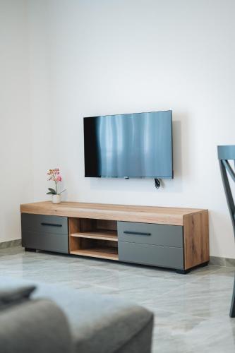 a flat screen tv sitting on top of a wooden entertainment center at ARA Lux Apartments in Utjeha