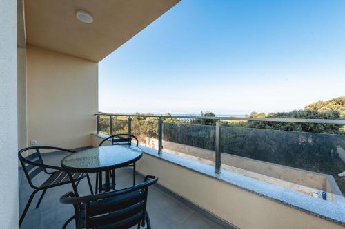 a balcony with two tables and a view of the ocean at ARA Lux Apartments in Utjeha