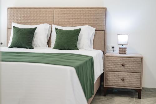 a bedroom with a large bed with green sheets and a night stand at ARA Lux Apartments in Utjeha
