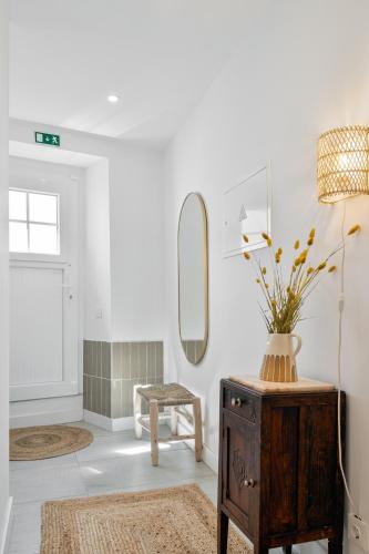 a room with a mirror and a table with a vase on it at Amber and Rust Estremoz City House in Estremoz