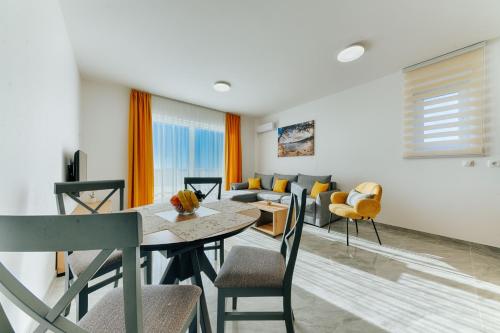 a living room with a table and chairs and a couch at ARA Lux Apartments in Utjeha