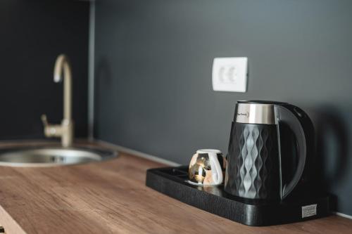 a black and silver coffee pot sitting on a counter at ARA Lux Apartments in Utjeha
