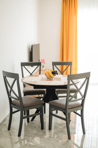 a table with four chairs and a bowl of bananas on it at ARA Lux Apartments in Utjeha