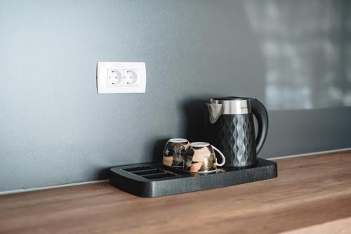 a coffee pot and mugs on a tray on a table at ARA Lux Apartments in Utjeha