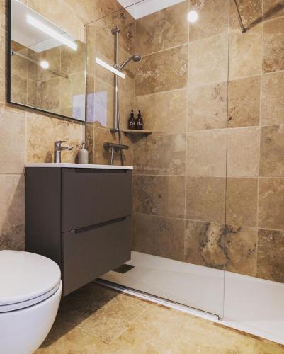 une salle de bain avec une douche, des toilettes et un lavabo dans l'établissement Maison d'architecte avec piscine au centre-ville, à Marseillan