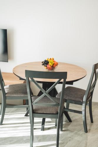 a table and chairs with a bowl of fruit on it at ARA Lux Apartments in Utjeha