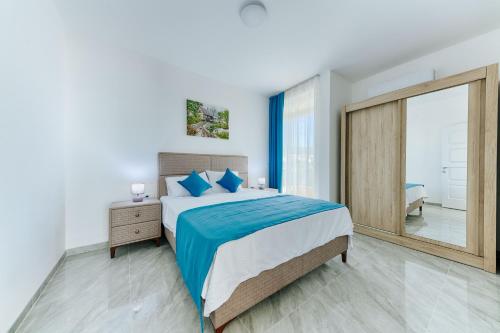 a bedroom with a large bed and a large mirror at ARA Lux Apartments in Utjeha