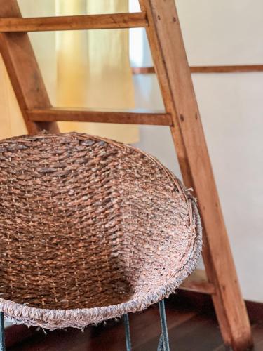 a wicker chair next to a wooden stool at Nubá Boutique Hostel Palomino in Palomino