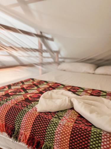 a bed with a quilt on top of it at Nubá Boutique Hostel Palomino in Palomino