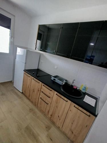 a kitchen with a sink and a black counter top at Apartman SARA in Bukorovac