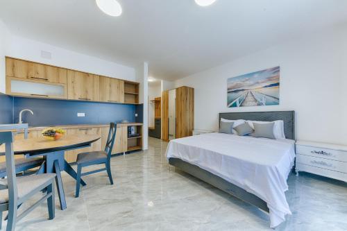 a bedroom with a bed and a table and a kitchen at ARA Lux Apartments in Utjeha