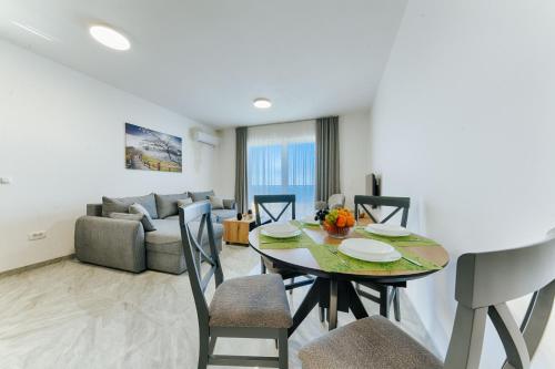 a dining room and living room with a table and chairs at ARA Lux Apartments in Utjeha