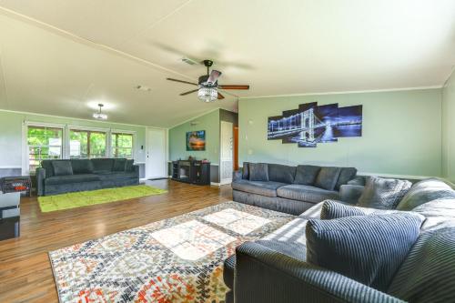 a living room with two couches and a ceiling fan at Palatka Hideaway with Fireplace and Private Porch in Clay Landing