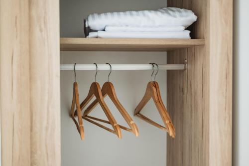 a shelf with three hangers in a closet at ARA Lux Apartments in Utjeha