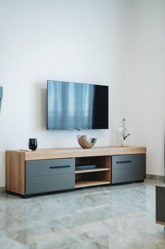a living room with a flat screen tv on the wall at ARA Lux Apartments in Utjeha