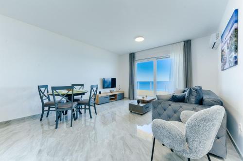 a living room with a couch and a table with chairs at ARA Lux Apartments in Utjeha