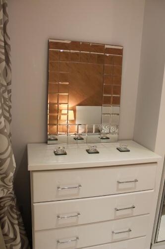 a white dresser with a mirror on top of it at St. Elmo Apartments in Valletta