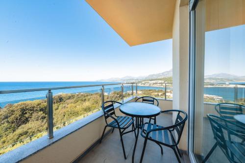 a balcony with chairs and tables and a view of the ocean at ARA Lux Apartments in Utjeha