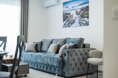 a living room with a blue couch in a room at ARA Lux Apartments in Utjeha
